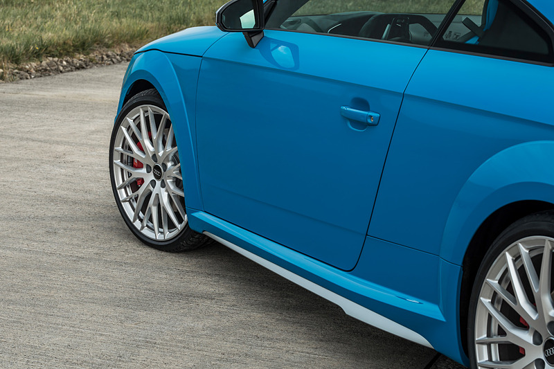 TTS クーペのエクステリアでは、シングルフレームグリルがマットシルバー＆マットブラックで構成されるとともに、アルミニウム調で仕上げられたワイドなフロントスプリッター、バーティカルエアインレット、トリムストリップなどを採用。リアまわりでは立体的なディフューザー、4本出しのテールパイプがデザインハイライトになる