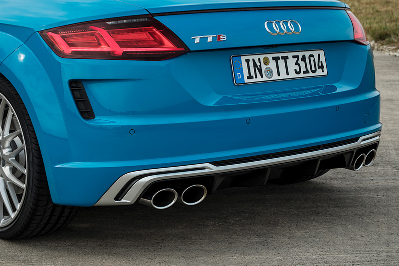 TTS クーペのエクステリアでは、シングルフレームグリルがマットシルバー＆マットブラックで構成されるとともに、アルミニウム調で仕上げられたワイドなフロントスプリッター、バーティカルエアインレット、トリムストリップなどを採用。リアまわりでは立体的なディフューザー、4本出しのテールパイプがデザインハイライトになる