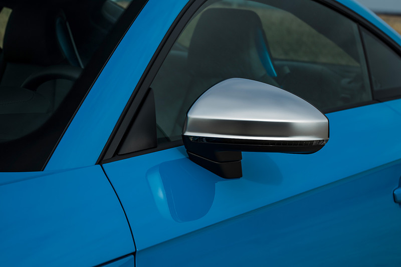 TTS クーペのエクステリアでは、シングルフレームグリルがマットシルバー＆マットブラックで構成されるとともに、アルミニウム調で仕上げられたワイドなフロントスプリッター、バーティカルエアインレット、トリムストリップなどを採用。リアまわりでは立体的なディフューザー、4本出しのテールパイプがデザインハイライトになる