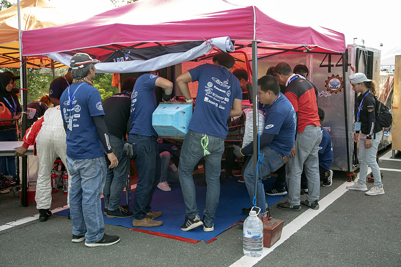 修正には燃料タンクを降ろすことが必要。そこで、持参していた長机を並べてその上にマシンを載せて、下面からの作業を行ないやすくしていた