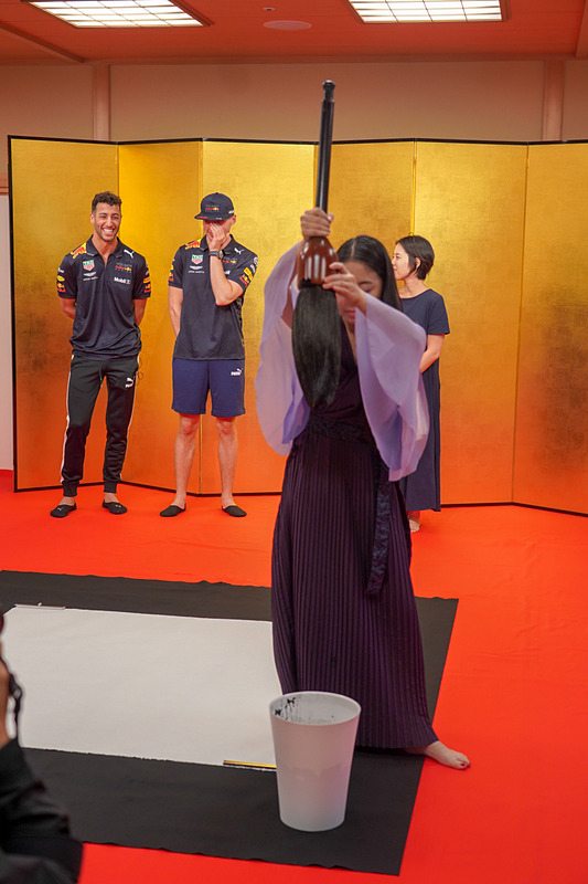 書道家の実演を興味深げに見る2人