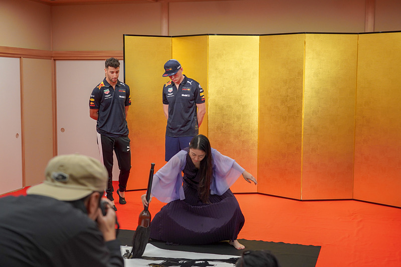 書道家の実演を興味深げに見る2人