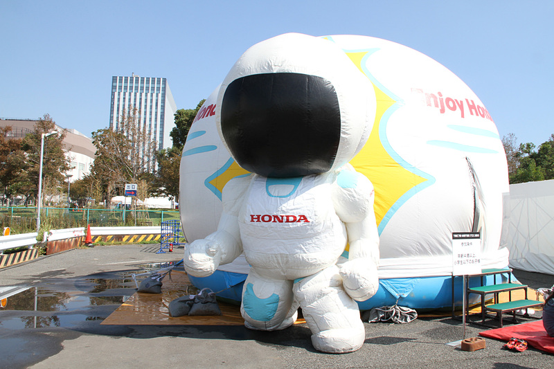 ホンダは2018年に創刊50周年を迎えた「週刊少年ジャンプ」とコラボした「フィット」のオリジナルラッピングカー展示をはじめ、約60度まで傾けた状態の「RC213V」や、ウィリーとジャックナイフを実物のトライアルバイクにまたがって体験できるコーナーを設置。エアドームの中で遊べる「Enjoy Honda ふわふわ」も用意される