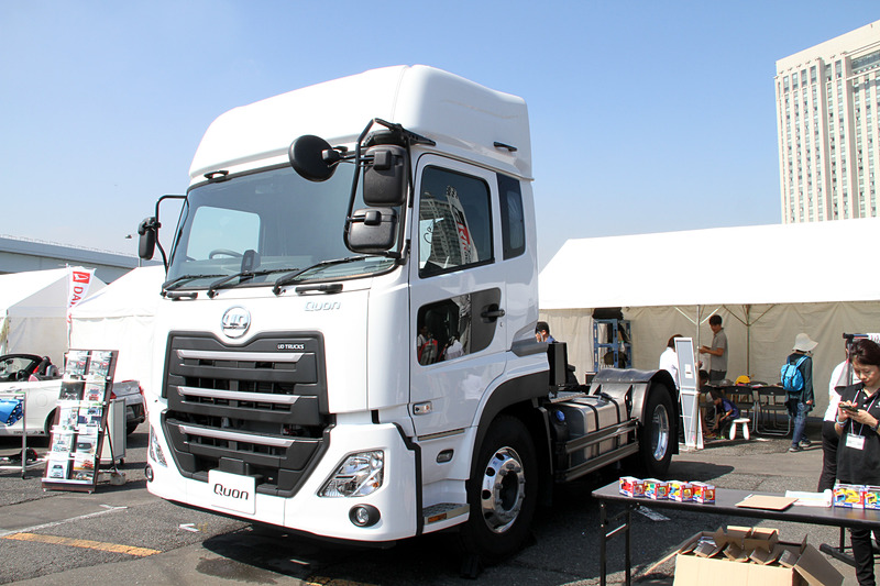 UDトラックスのブースでは、子供用のつなぎを着用して大型トラック「クオン」の前で記念撮影ができる。この写真をハッシュタグ「#UDキッズメカニック」をつけてインスタグラムに投稿すると、クオンのミニカーがプレゼントされるキャンペーンも展開している