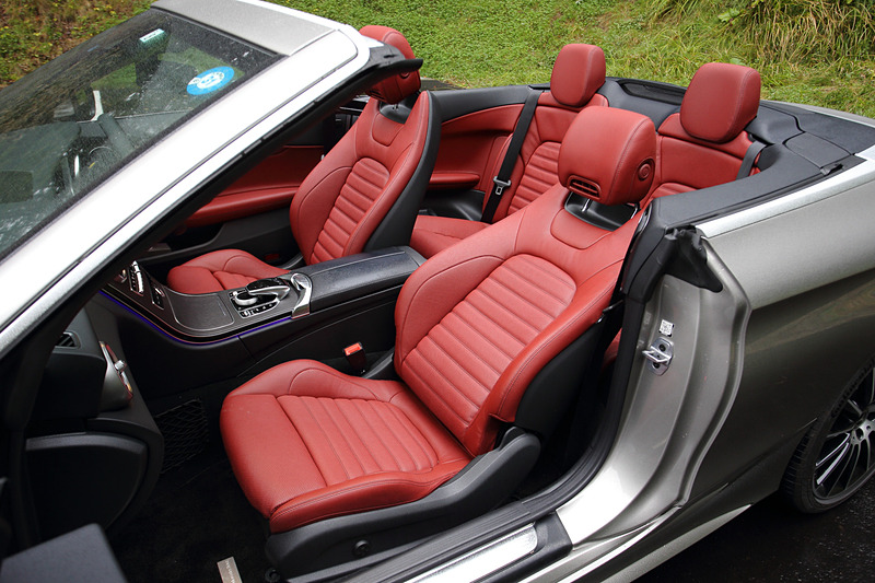 クランベリーレッドカラーのインテリア。フロントウィンドウ上部にディフレクターが備わり、空気の流れを上方に跳ね上げることで室内への風の巻き込みを抑制。また、前席のヘッドレストからは温風が出るので寒い日でもオープンドライブが楽しめる