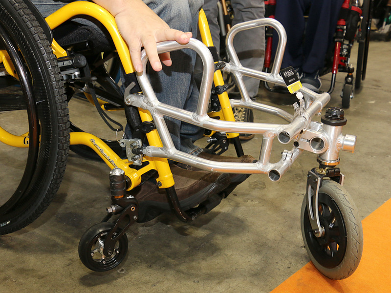 雪に埋まりがちなフロントキャスターにかわり、大きいタイヤ1輪を車いすの前に装着することで、雪道での走破性をアップ