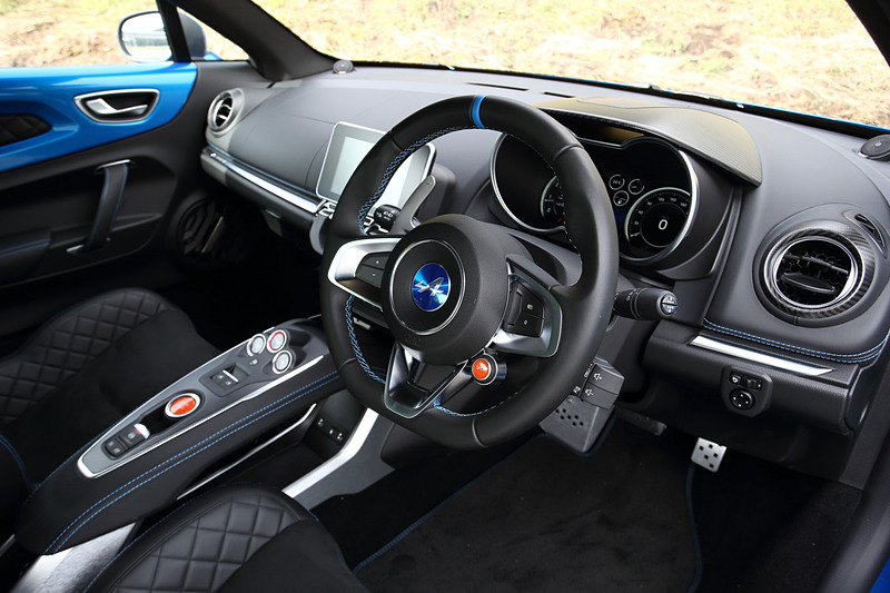 マットカーボン/アルミ/レザーを組み合わせるピュアグレードのインテリア。1脚あたり13.1kgという軽量を誇るSabelt製モノコックバケットシートをはじめ、レザーステアリング/ブルーステアリングセンタートリム、FOCAL製軽量4スピーカーなどを標準装備