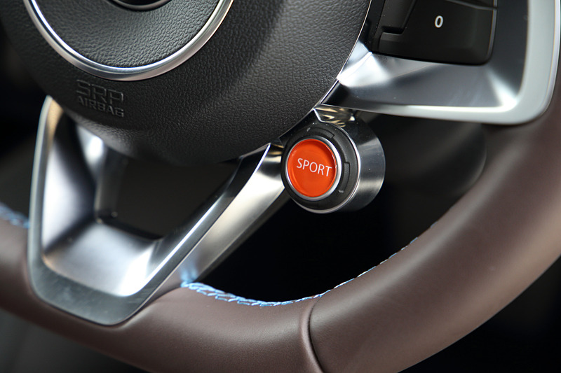 ブリリアントカーボン/アルミ/レザーを組み合わせるリネージグレードのインテリア。ブラウンレザーのSabelt製スポーツシート（シートリフター・リクライニング、シートヒーター付き）のほか、レザーステアリング/ブラックステアリングセンタートリム、FOCAL製軽量4スピーカー＋サブウーファーなどが専用装備になる