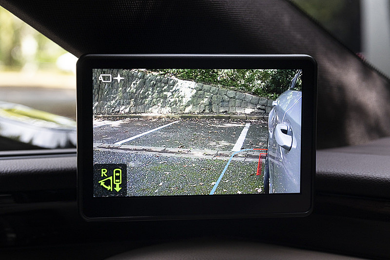 駐車場内の同じ位置で、シフトセレクターをリバースに動かした時の画面表示の変化。自車のリアタイヤから隣の駐車枠までしっかり映っているほか、ブルーのラインで安全性が確保できるエリア、レッドのラインで接触の危険性があるエリアを示している