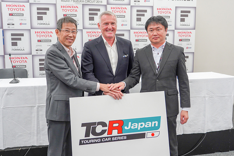 記者会見終了後に握手しながら会見に臨む3者