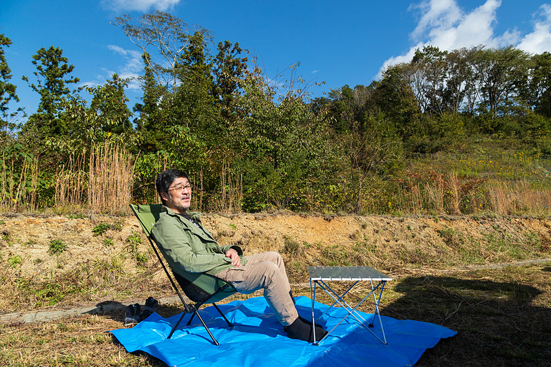 クルマを指定された場所に駐め、テント設営の時間ではないのでとりあえずスペースを確保しておく。グランドシート代わりのブルーシートの上で物思う高橋