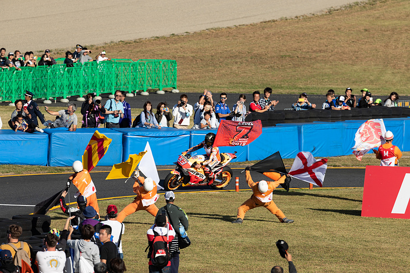 別の意味でスタンドを湧かせたのが、ピットに戻る選手を迎えたコースマーシャルのフラグパフォーマンス。ライダーがガン見するほど見事なものだった