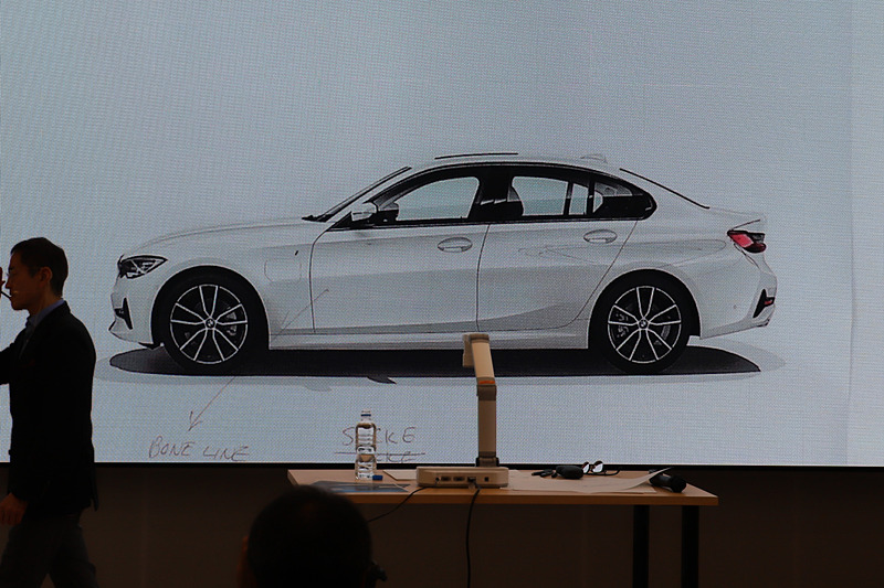 サイドのボディラインについて。「ボディカラーが白なので分かりづらいかもしれない」と話しつつ、写真に書き込みをしながらボーンラインやリアホイールを強調するデザインを説明