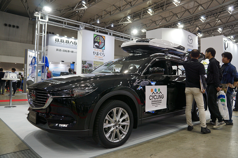 自転車を搭載するトレーラーをけん引するマツダ CX-8の展示も