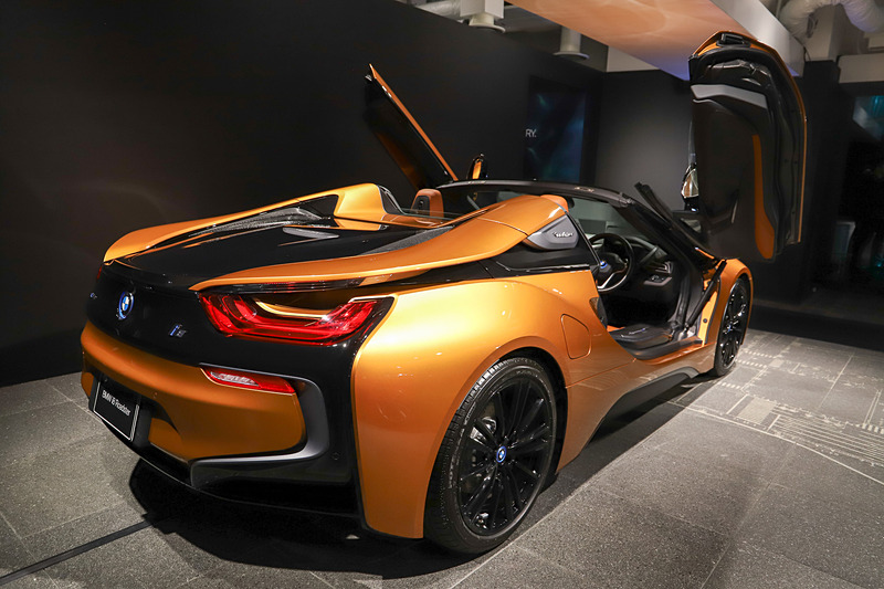 i8 ロードスターのボディサイズは4690×1940×1290mm(全長×全幅×全高)で、ホイールベースは2800mm。最高出力170kW(231PS)/5800rpm、最大トルク320Nm(32.6kgfm)/3700rpmを発生する直列3気筒DOHC 1.5リッター「B38K15A」型エンジンと、最高出力105kW(142.8PS)/4300rpm、最大トルク250Nm(25.5kgfm)/100-4100rpmを発生する「P250」型電気モーターを搭載し、システムトータルでは最高出力275kW(373.9PS)、最大トルク570Nm(58.1kgfm)を発生する。展示車両はソフトトップを開けた状態だった