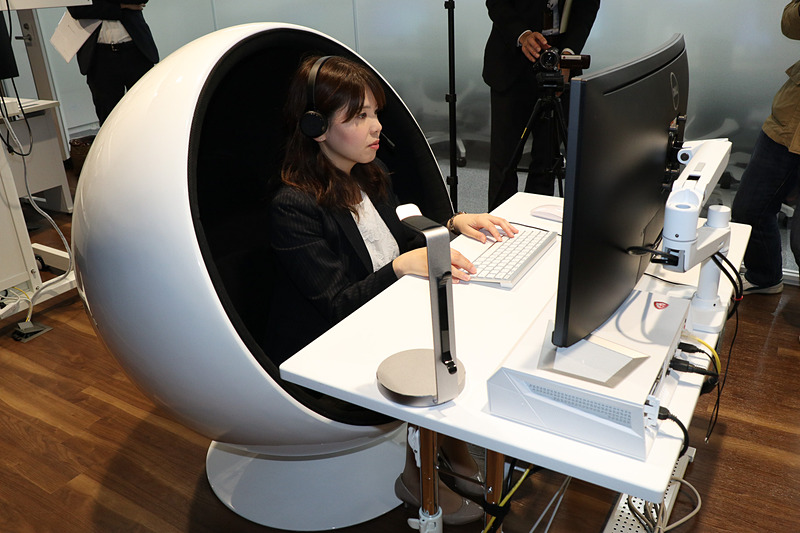 オペレーターや遠隔運転担当者が離れた場所にいる自動運転車の乗員との対応に集中できるよう、コネクテッドサポートセンターでは半球型の特殊なシートを採用。後方から見ると誰もいないようだが、デモ実施に向け、すでに女性オペレーターがスタンバイしている