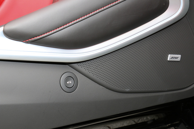 ドアトリムのソフトパッドも赤と黒のコンビネーションとなる。トランクリッドのオープナーをドアパネルの下側に設定