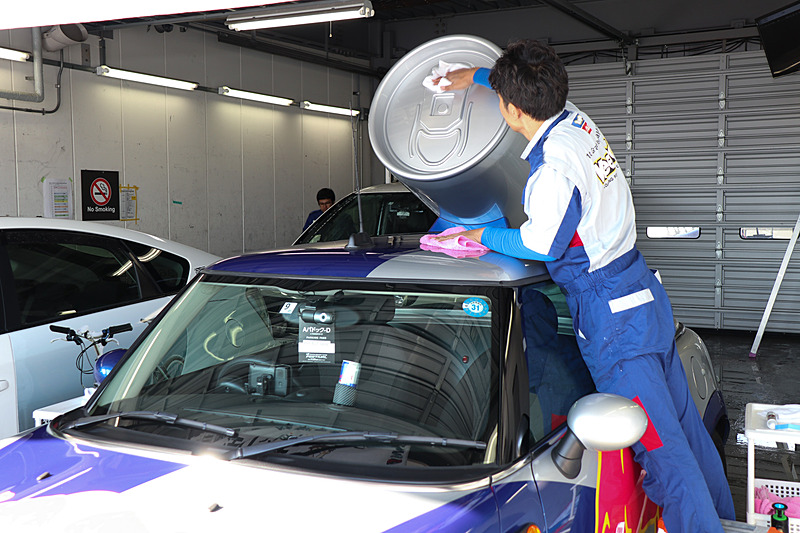 ブースから少し離れ、水の使用が許可されたピットビルBでコーティングの施工デモを披露。午前中にくじ引きで当選した来場者の車両にもコーティングが行なわれていた
