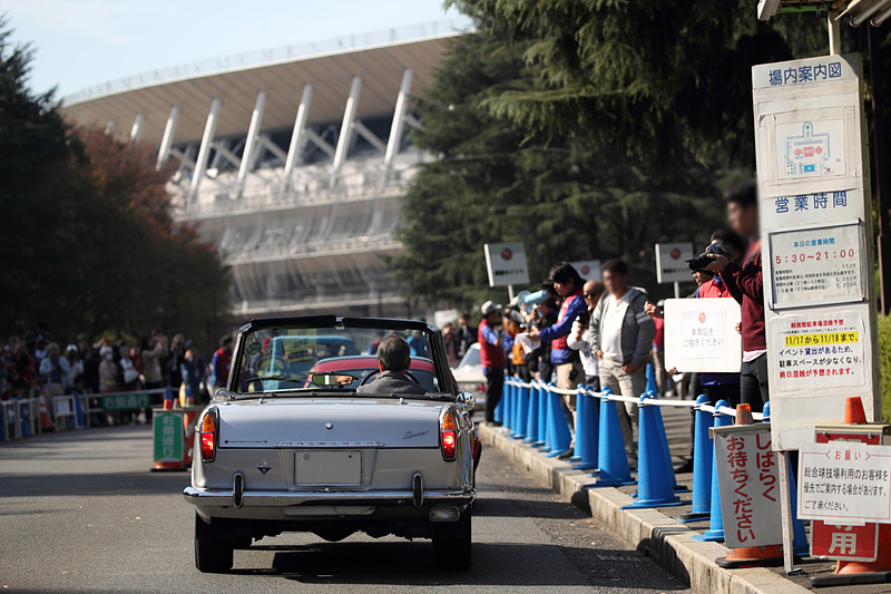 パレードを終えた車両が続々と神宮外苑に戻ってきた。前方に見えるのは2020年に向けて建設中の新国立競技場