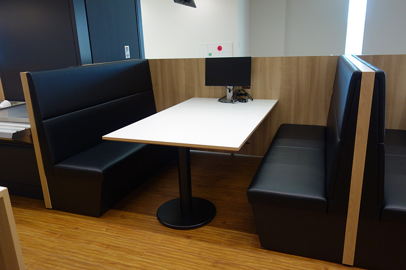 2階の食堂では食事する人数に合わせてさまざまな形状のテーブルが用意される。モニターにはメニューとともに残数の表示も。ユニークなのはフロアに書かれた英数文字。この日はAメニューが「カレー」（300円）だったが、「A/56」と書かれたところは「カレーに56人が並んでいます」という意味。ひと目で何のメニューにどれくらいの人が並んでいるかが分かるようになっている