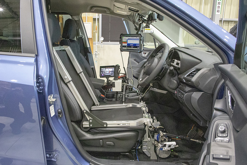 試験車の装備。ドライバーは乗車するが、人間が運転するのはクルマの位置を決めたりする時だけで、試験開始になるとPCに入っている試験プログラムに沿って「アクセルロボット」がペダルを操作。ドライバーは何も操作しない