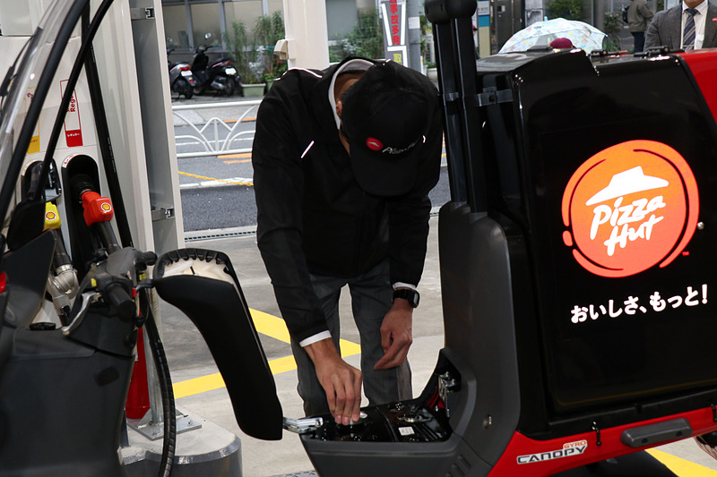 ピザハット代々木の作田耕造店長の手で、デリバリー用バイクのシート下にある燃料タンクに無事給油された