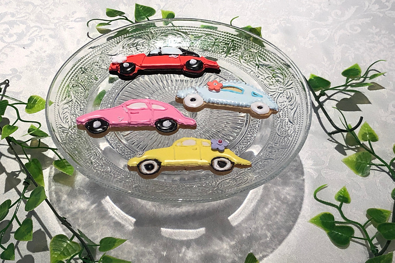 完成した生徒4人のクルマクッキー！　私のは黄色いビートル。あとは名前は伏せますが（笑）、みんなそれぞれの個性が出てるなぁ～と思います。しかも、いちばんクールだと思っていた人が、いちばんラブリーな仕上がりになってみたり、思わぬ本性が表れるものなのかも!?　これも立派な「クルマの楽しみ方」だなぁと思いました