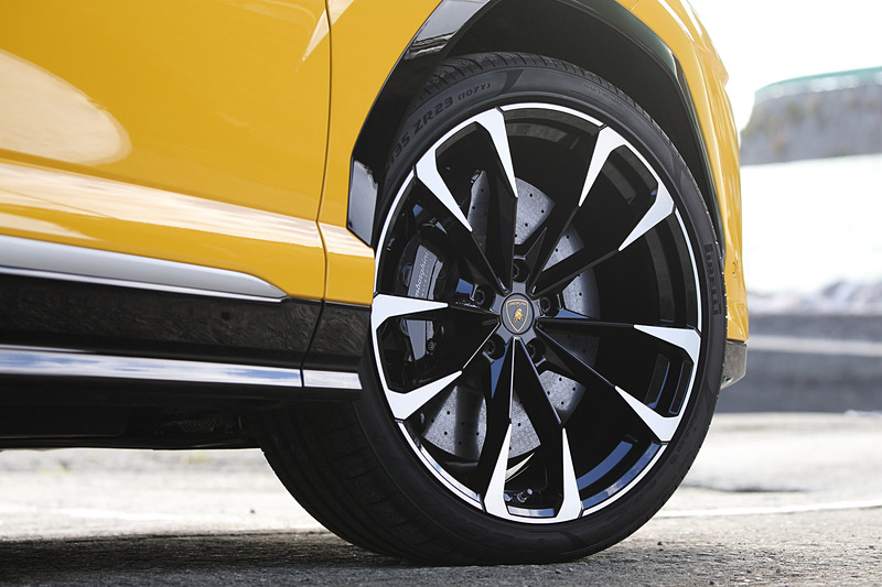 ウルスでは車速と選択したドライブモードに応じて最大で±3.0度のリアステアリング角を設ける、「アヴェンタドール S」でも導入されたリアホイールステアリングを採用。低速時は後輪が前輪のアングルの反対を向いてホイールベースを最大600mm相当短縮する効果を得ることができ、高速時は後輪が前輪と同じ方向に切れ、ホイールベースを最大600mm長くする効果が得られる。足下は23インチホイールにピレリ「P ZERO」（フロント：285/35 ZR23、リア：325/30 ZR23）の組み合わせ