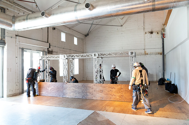 ステージや照明、音響などの必要機材が持ち込まれ、それぞれの専門チームが手際よくセットを組み上げていく