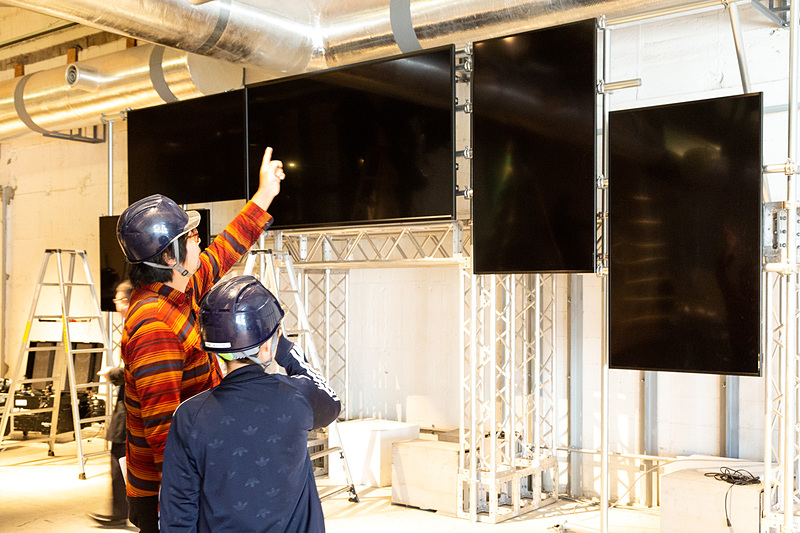 ステージや照明、音響などの必要機材が持ち込まれ、それぞれの専門チームが手際よくセットを組み上げていく