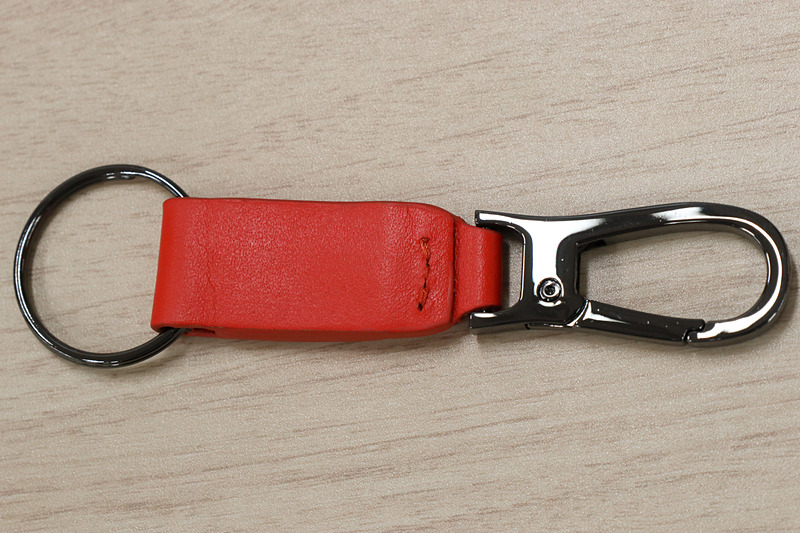 オレンジのレザーとクロームメッキのリングなどを組み合わせたキーチェーン。中央にModuloロゴの入ったクロームメッキプレートも備える