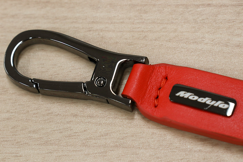 オレンジのレザーとクロームメッキのリングなどを組み合わせたキーチェーン。中央にModuloロゴの入ったクロームメッキプレートも備える