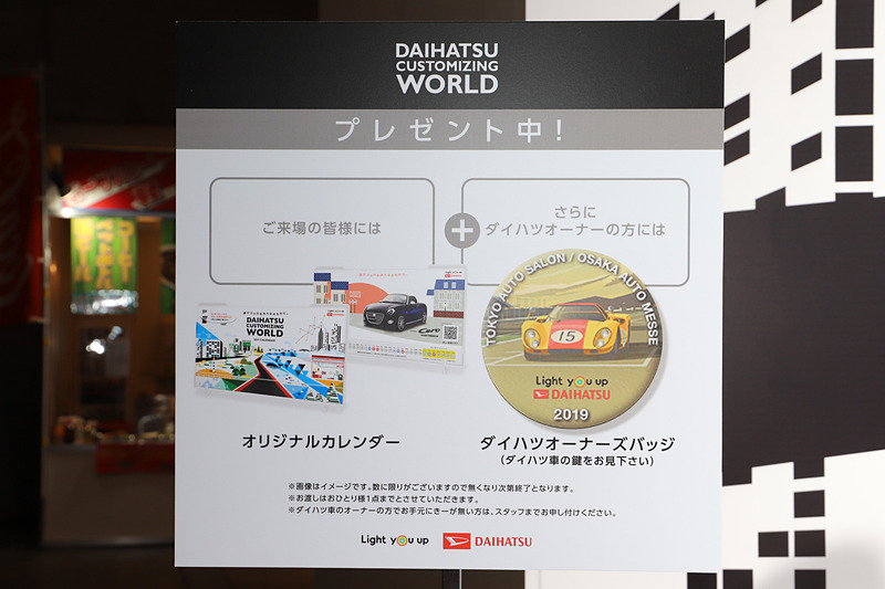 ダイハツブースでは、来場者全員に展示車両がデザインされたオリジナルカレンダーのほか、ダイハツ車の鍵をスタッフに見せると限定の「ダイハツオーナーズバッヂ」をプレゼントしている