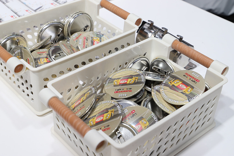 ダイハツブースでは、来場者全員に展示車両がデザインされたオリジナルカレンダーのほか、ダイハツ車の鍵をスタッフに見せると限定の「ダイハツオーナーズバッヂ」をプレゼントしている