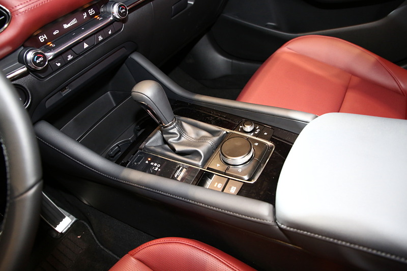 ハッチバック専用色となる「ポリメタルグレーメタリック」に塗装された新型Mazda3 CUSTOM STYLE（北米仕様ベース）。インテリアカラーはバーガンディで、マツダの新たな世界観を表現。エクステリアでも専用のエアロパーツを装備していて、ステージに飾られた「ソウルレッドクリスタルメタリック」や「マシーングレープレミアムメタリック」の新型Mazda3とは異なったテイストを醸している