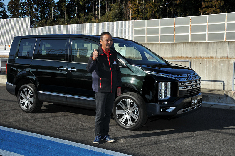 増岡選手と標準の新型デリカD：5。エメラルドブラックパールとアイガーグレーメタリックのツートーンの有料色。エメラルドブラックパールは、暗めだと基本ブラックの見えるが、光が当たるとグリーンのパールが映える