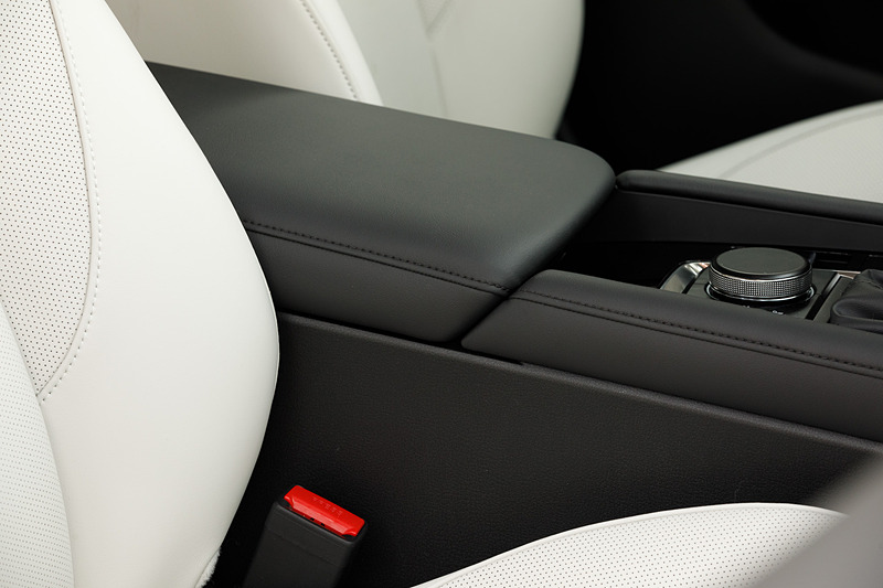 4ドアセダンのインテリア。5ドアハッチバックともどもマツダらしくドライビングポジションにもこだわり、ステアリングのテレスコピック量を前後10mmずつ拡大し、合計で70mmの調整幅を持たせることで体格に応じたドライビングポジション調整の精度を高めた。シフト位置は現行モデルに対してAT/MTともに前方・上方に移動させ、ステアリングからの持ち替えのしやすさとシフト操作のしやすさを向上させたという