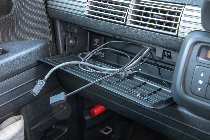 8インチプレミアムインターナビ（VXM-187VFEi）につながるUSBケーブルとHDMIケーブルも付けた。ケーブルは助手席のダッシュボードから出てくるが、フタがないのでごちゃつく。そこで純正アクセサリーの「インパネトレイリッド」（5400円）を装着。右上をプッシュすると開く作り。多少あと付け感があるけど、ケーブルが隠せたのでヨシとする