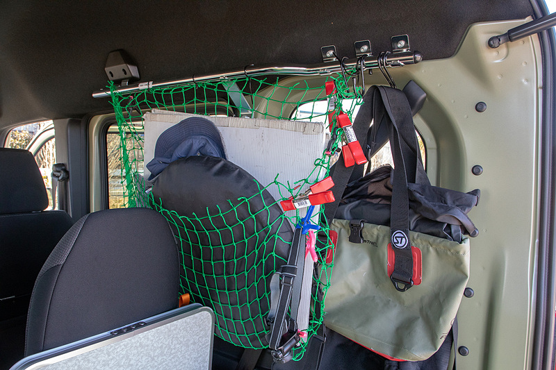 そこそこ便利だったルーフネットだが、机と椅子を出すオフィスモードのときや立って作業するときにネットがジャマで、その都度片方を外していたが、あるとき「下側を持ち上げて袋状にするとよいのでは？」と閃いた。そしてクリップで挟んで袋っぽくしてみたところこれがすごく便利。大きなものから小さいものまでポイポイ入るし、右の後ろなら視界のジャマにならない。純正採用を希望しますっ！