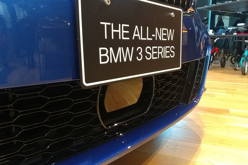 フロントガラス上部に装着される「トリプル・カメラ」。それぞれで短距離（広角）、中距離、長距離を担う。なお、ナンバー下にミリ波レーダーが設置されているため、日本仕様のナンバーを装着するとやや重なる形となっていた