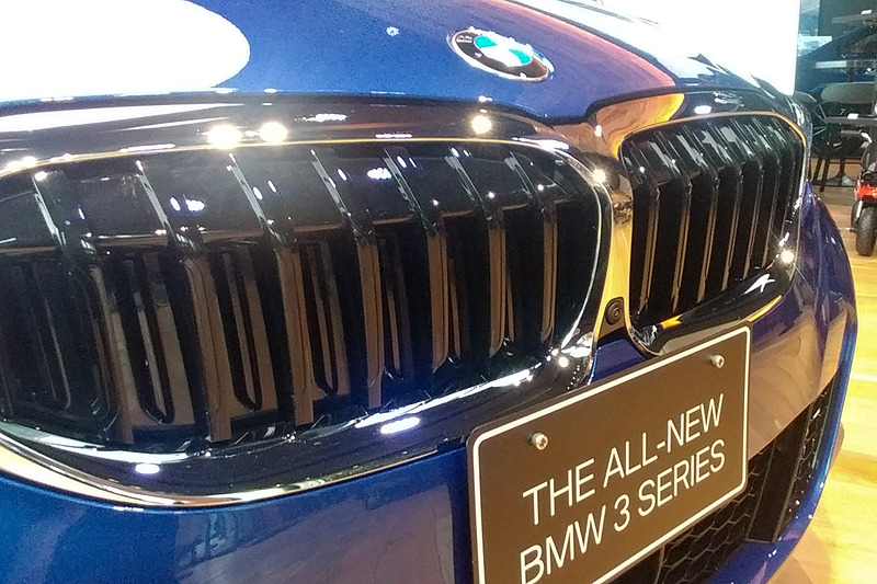 フロントガラス上部に装着される「トリプル・カメラ」。それぞれで短距離（広角）、中距離、長距離を担う。なお、ナンバー下にミリ波レーダーが設置されているため、日本仕様のナンバーを装着するとやや重なる形となっていた