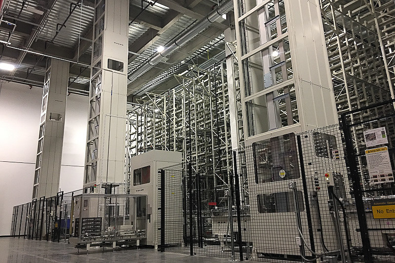 米国 ネバダ州にある「ギガファクトリー」内にある電池セルの出荷倉庫（左）と、ギガファクトリーで生産される「2170」電池（右）