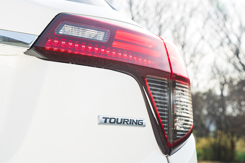 ツーリングのエクステリアではブラック塗装のヘッドライトガーニッシュやクロームメッキのフロントグリル、左右2本出しのエキパイフィニッシャーといった専用装備を採用。足下はグレー塗装の18インチアルミホイールにミシュラン「プライマシー 3」（225/50 R18）の組み合わせ