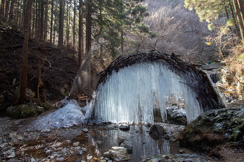 冬期は滝の氷瀑をイベントにしていて、途中に地元の人が作る氷のオブジェがある。縄のアーチを掛け、そこに川の水をポンプでくみ上げて掛けているだけだが、寒いので写真のように凍る。ただ、2月後半の気温ではもう見られない