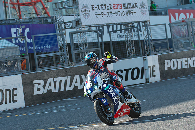 手を振りながらホームストレートに戻ってきたフック選手は、途中で手渡された青地に赤の日の丸、白抜きで「必勝」と書かれた独自のトリコロールフラッグをはためかせて走行