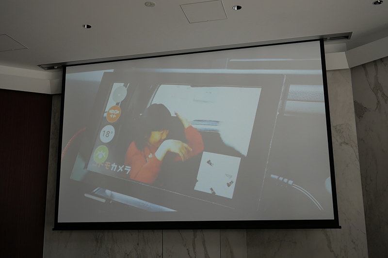 スマートフォンのカメラを利用して後部座席の子供を撮影し、前方のSDL対応車載機で確認できる