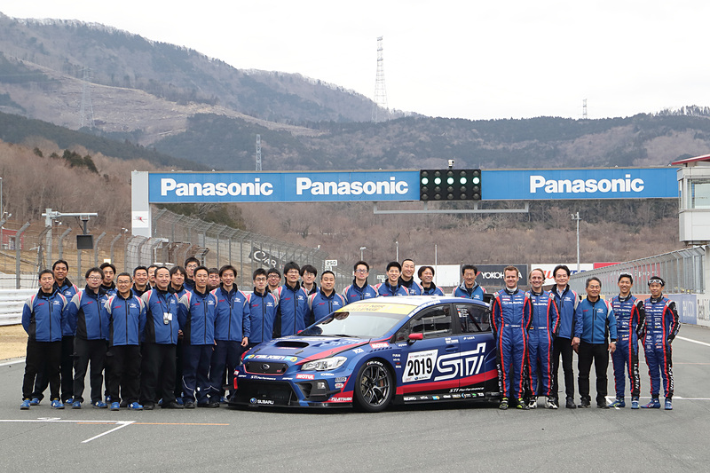 富士スピードウェイのホームストレートに並ぶ新しいSUBARU WRX STIとチームスタッフ
