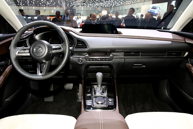 コクピットまわりの左右対称なデザインや、スイッチとエアコン吹き出し口の横基調は新型「Mazda3」と同様となる。CX-30の特徴は、助手席側からダッシュボード上部に回り込み、空間を包み込むようなデザイン。パッセンジャーカーとして居心地のよい室内を生み出すために施された、独自のインテリアとなる