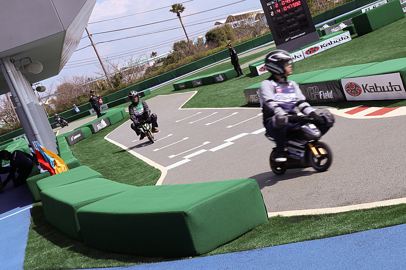 当日は報道機関向けの先行披露会が行なわれたため、大人も多数参加。取材ということでスーツ姿で小さなEVレーサーを走らせる人も。体格が合わない大人は重心が高く、ちょっと気を抜くとふらついて、子供とは違ったスリリングさを味わえる。体格や体重の制限はとくに設けていないとのこと