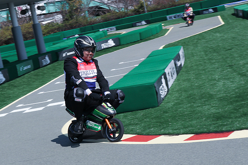 当日は報道機関向けの先行披露会が行なわれたため、大人も多数参加。取材ということでスーツ姿で小さなEVレーサーを走らせる人も。体格が合わない大人は重心が高く、ちょっと気を抜くとふらついて、子供とは違ったスリリングさを味わえる。体格や体重の制限はとくに設けていないとのこと